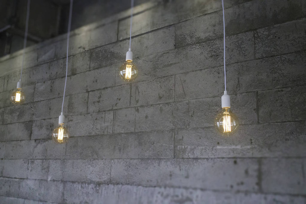 Винтажные лампы накаливания типа Эдисон на серой стене, фото со склада - Фото, изображение