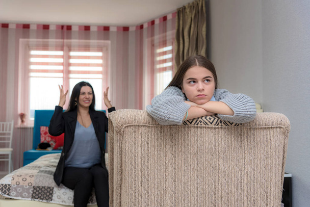 Family problems, family relationships mother and teen daughter in a room on the sofa. They sit on the sofa and look displeased. - Foto, immagini