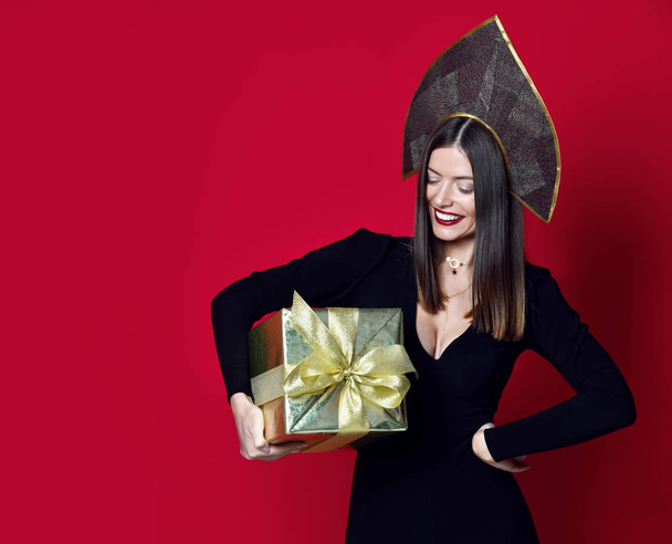 Beautiful woman hold gold Christmas presents gifts for new year celebration in kokoshnik hat - Foto, afbeelding