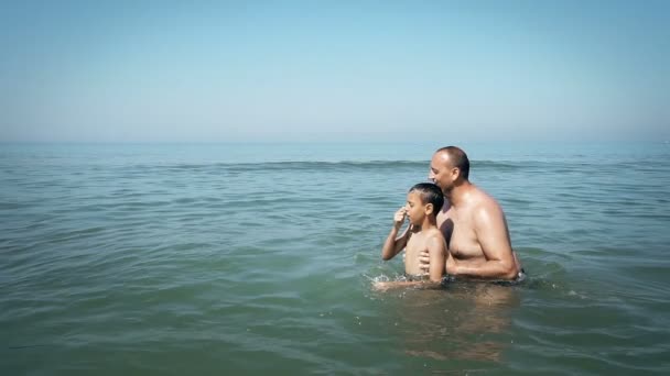 Father throwing his son on the beach. Concept of friendly family, SLOW MOTION - Séquence, vidéo
