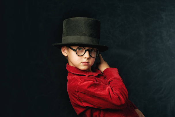 portrait of a boy close-up on a dark background . Child in red stylish shirt - Фото, зображення