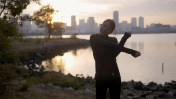 Fit Woman preparing herself for a run in the early morning. - Materiaali, video