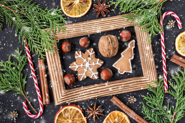 Christmas wooden background with gingerbread cookies. Top view with copy space for your greetings. Christmas and New Year holiday background. Winter holidays concept.  - Photo, Image