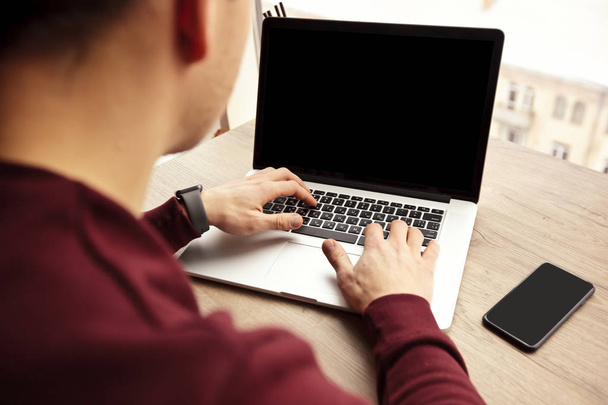 Um jovem está trabalhando em seu laptop
 - Foto, Imagem
