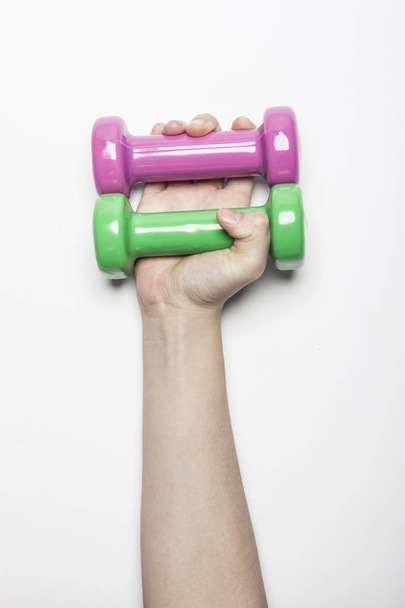 Woman hand hold a Dumbbell on the white background. - Fotoğraf, Görsel