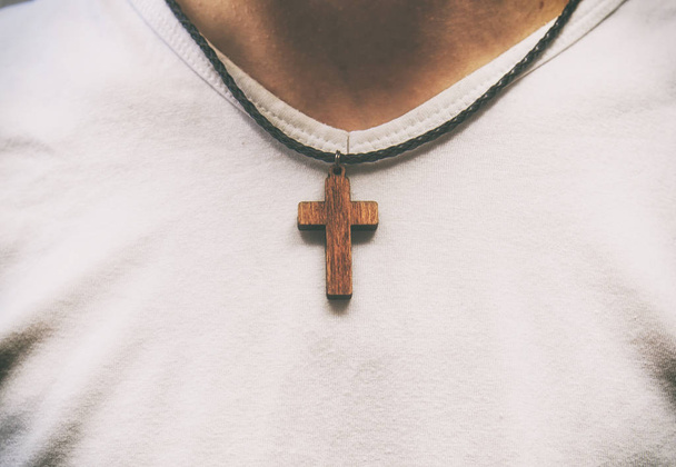 The wooden cross necklace on man's neck - Фото, изображение