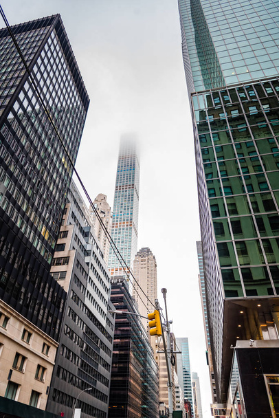 Nízký úhel pohledu mrakodrapů a mlhavý den - Fotografie, Obrázek