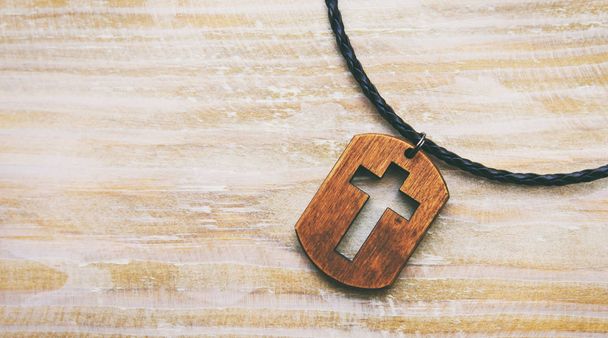 The cross-shaped pendant on the wooden desk - Foto, Imagem