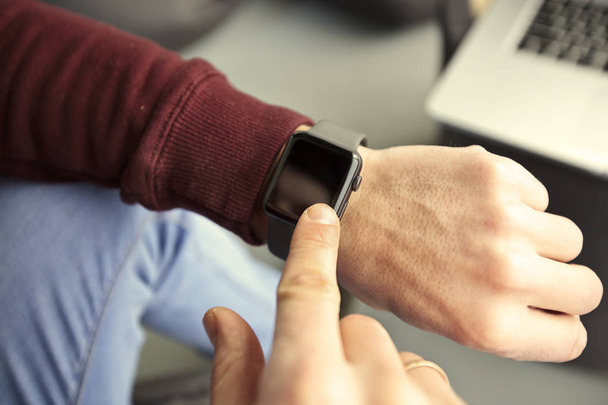 The man  is looking on his smart watches on his hand - Fotoğraf, Görsel