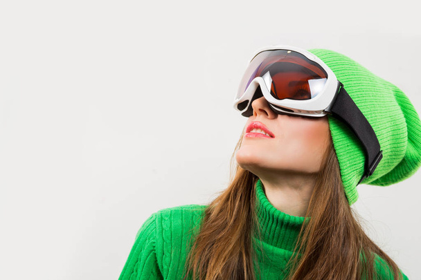 Активный портрет молодой лыжницы в зимней одежде, изолированной над белым
 - Фото, изображение