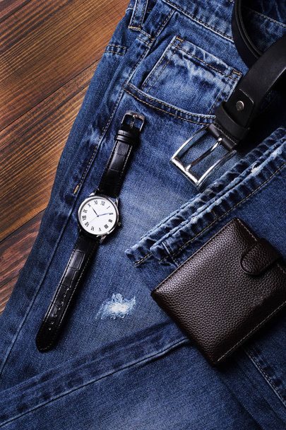 Módní džíny, hodinky, peněženku, pásek a hodinky na hnědé pozadí - Fotografie, Obrázek