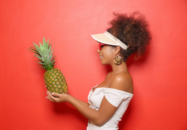 Beautiful African-American woman with pineapple on color background - Fotografie, Obrázek