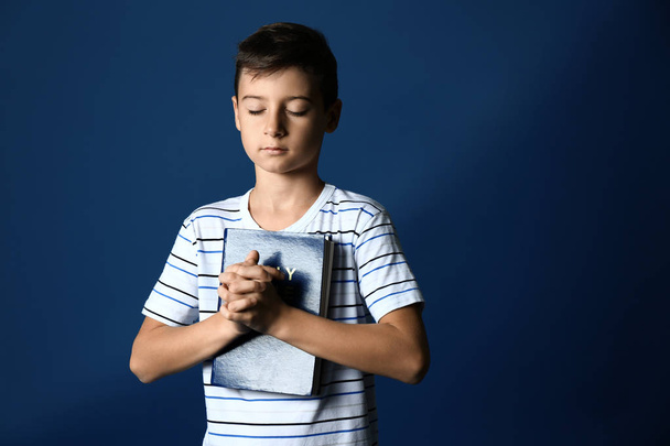 Pieni poika rukoilee värillinen tausta
 - Valokuva, kuva