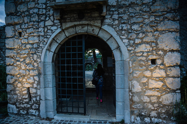 Тропинка или ворота на двери старого замка с девушкой-туристкой в i, Трсат Хорватия
. - Фото, изображение