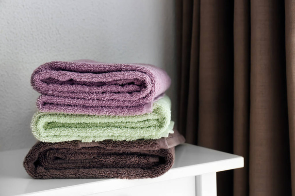 Montón de toallas suaves limpias en la mesa de luz
 - Foto, imagen