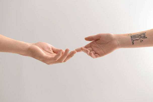 Homme et femme touchant les doigts sur fond clair
 - Photo, image