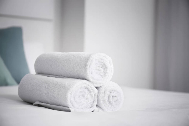 Gerolde witte handdoeken op bed - Foto, afbeelding