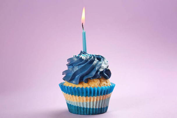 Renk arkaplanında yanan mum olan lezzetli bir doğum günü keki. - Fotoğraf, Görsel