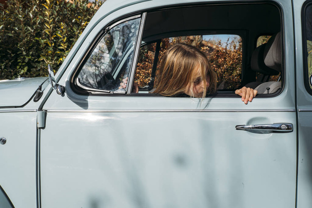 Little blonde girl in the car window - Photo, Image