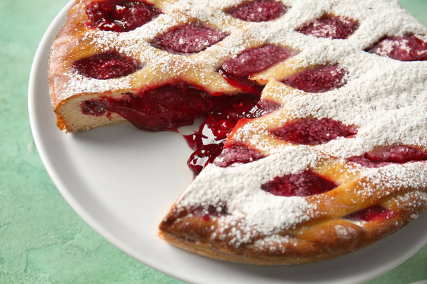 Cut tasty Christmas pie stuffed with cranberries on color table, closeup - Photo, Image