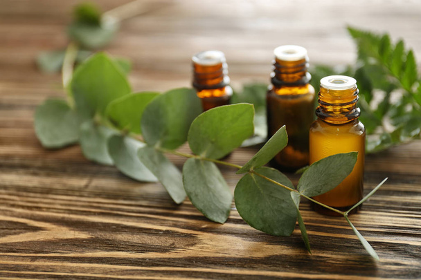 Botellas de aceite esencial de eucalipto sobre mesa de madera
 - Foto, Imagen