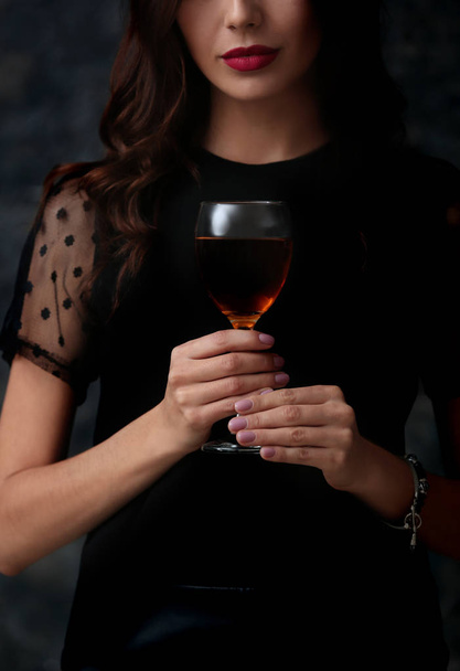 Beautiful young woman with glass of wine on dark background - Фото, зображення