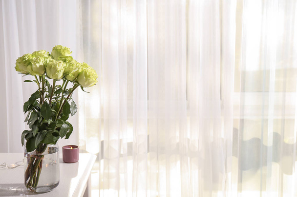 Vase avec de belles roses vertes sur table blanche dans la chambre
 - Photo, image