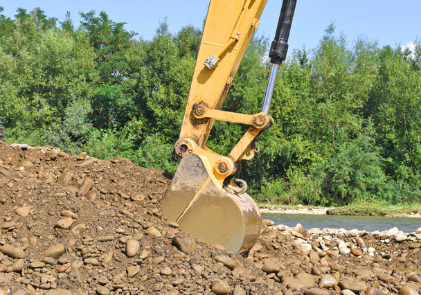 Grind in het autolichaam op de bouw van een beschermende dam laden  - Foto, afbeelding