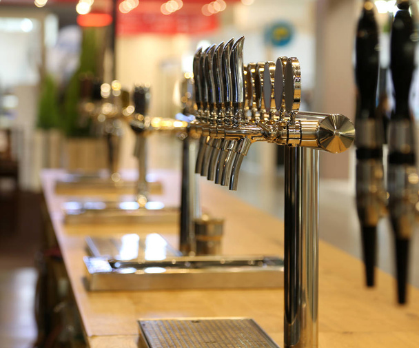 molti rubinetti di birra sul bancone di un pub
 - Foto, immagini