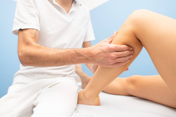 Delicate calf massage in a professional physiotherapist's studio. - Foto, imagen