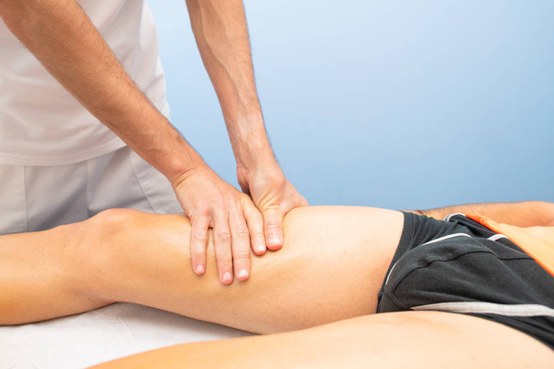Quadriceps massage to an athlete by a physiotherapist. - Fotografie, Obrázek