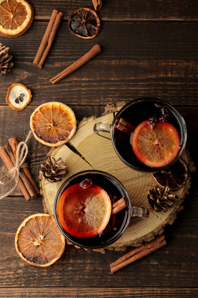 Vin chaud chaud chaud avec cannelle et orange dans des tasses en verre sur un fond sombre. Noël. Nouvel An. vue d'en haut
 - Photo, image