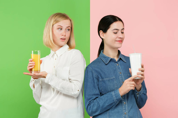 Diety. Pojęcie diety. Zdrowe jedzenie. Pięknych młodych kobiet wyboru między owoc pomarańczowy sok i unhelathy gazowany napój słodki - Zdjęcie, obraz