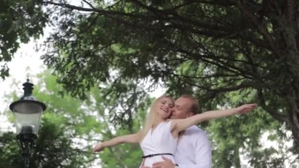 Nuori pariskunta kävelee puistossa. Pidä hauskaa ja iloitse. Mustavalkoiset vaatteet
 - Materiaali, video