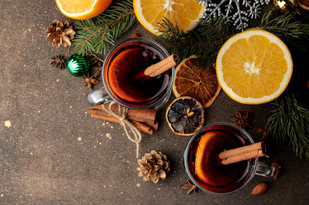 シナモン、オレンジ色のガラスのカップと暗い背景のクリスマスの装飾をホットホット ワイン。上からの眺め。クリスマス。新しい年. - 写真・画像