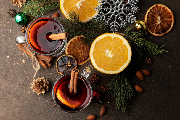Hot mulled wine with cinnamon and orange in glass cups and Christmas decorations on a dark background. View from above. Christmas. new Year. - Photo, Image