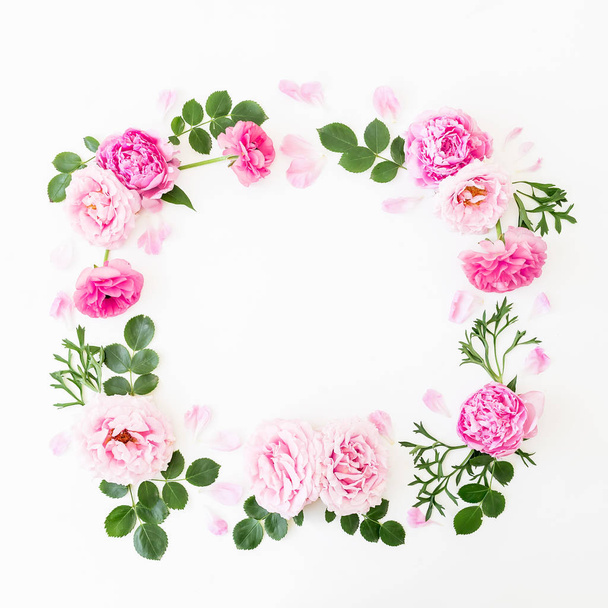Floral frame of pastel pink roses, peonies and green leaves on white background. Flat lay, top view. Spring time composition - Photo, Image