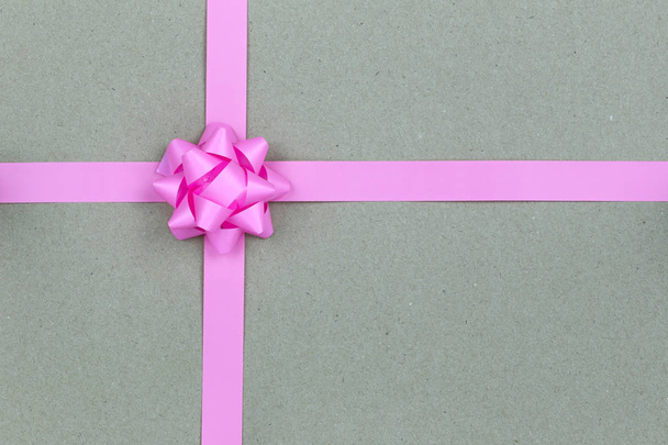 Christmas Pink Bow and ribbon on brown paper background,Top view on gift box of Special festival. - Photo, Image