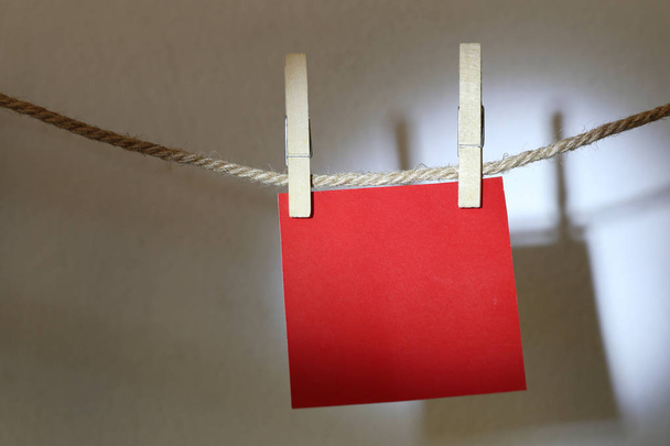 Papel vermelho pendurado na corda na parede branca e tem caminhos de recorte
. - Foto, Imagem