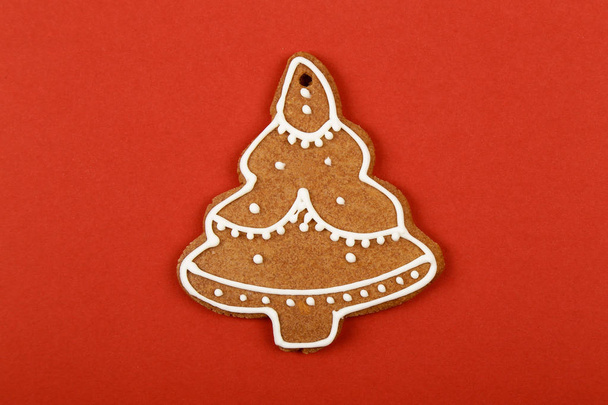 Christmas cookies, gingerbread In the form of a Christmas tree on red background. Christmas background - Foto, Imagem