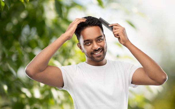indian man brushing hair over natural background - Foto, Imagem
