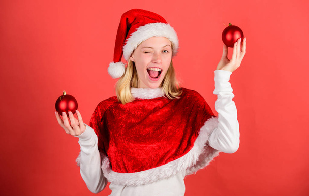Lets have fun. Girl happy wear santa costume celebrate christmas hold ball decor red background. Favorite time year christmas. Merry christmas and happy new year. Christmas preparation concept - Foto, imagen