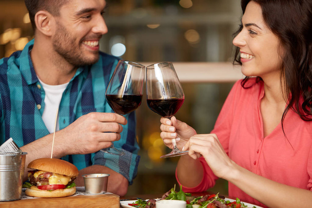 couple eating and drinking red wine at restaurant - Фото, зображення