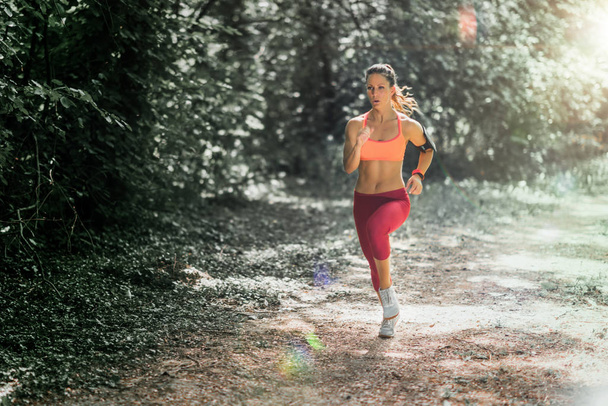 Молодая спортсменка бегает в парке
 - Фото, изображение