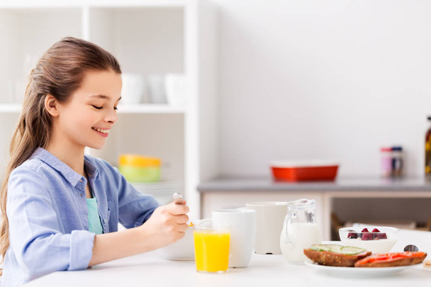 happy girl having breakfast at home - Valokuva, kuva
