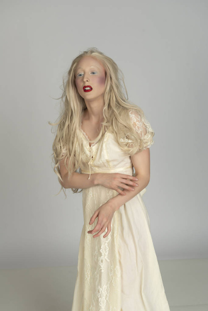 Бледная молодая блондинка в жёлтом платье
 - Фото, изображение