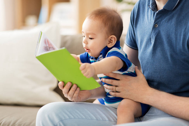 baby boy and father with book at home - Фото, зображення