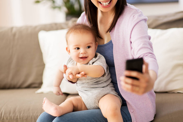mother with baby taking selfie at home - Foto, imagen