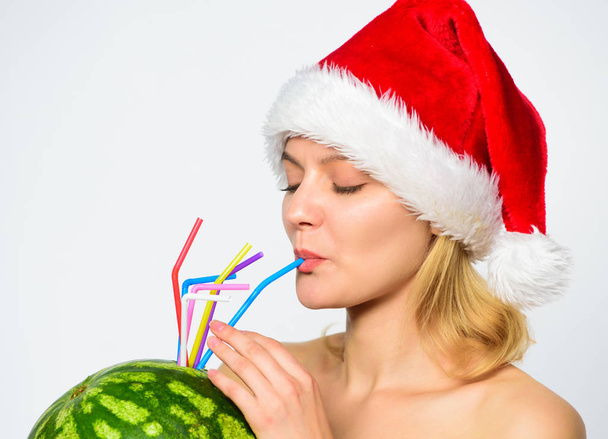 How to detox after christmas. Watermelon dietary detox beverage. Woman enjoy detox drink. Girl attractive nude wear santa hat drink watermelon cocktail straw white background. Winter detox concept - Foto, afbeelding