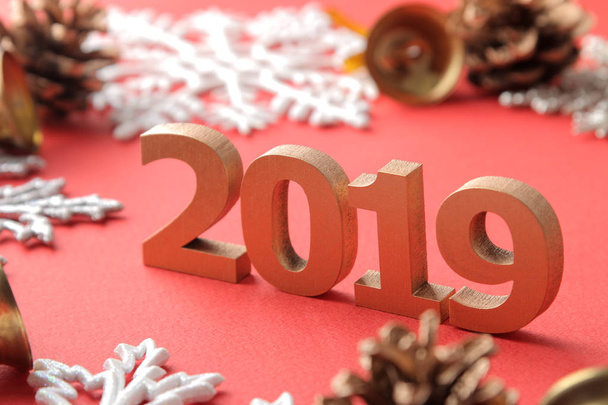 Inscripción de primer plano 2019 y copos de nieve y decoración navideña sobre fondo rojo
. - Foto, imagen